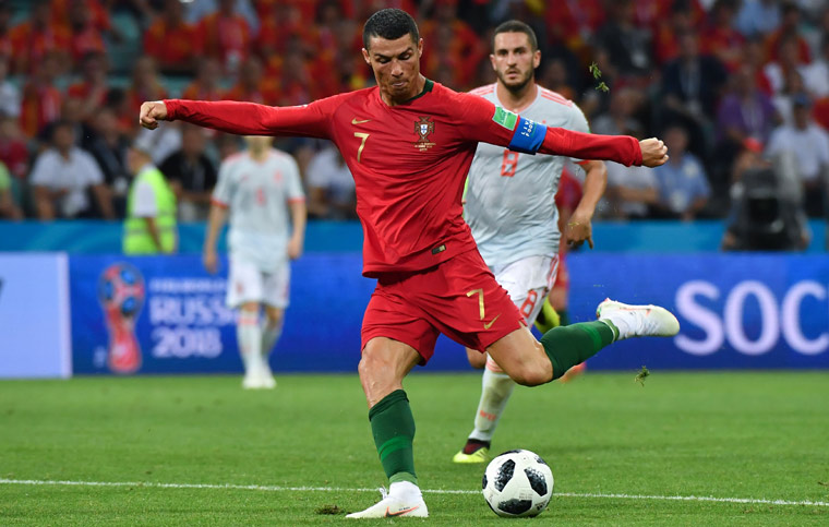 Cristiano Ronaldo shoots to score his second goal during the FIFA World Cup 2018 Group B match between Portugal and Spain | AFP