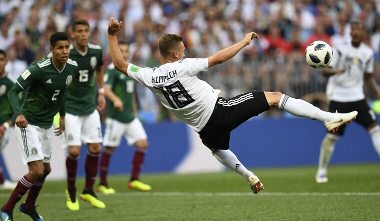 Germany's Joshua Kimmich (centre) jumps to shoot the ball during the group match against Mexico | AFP