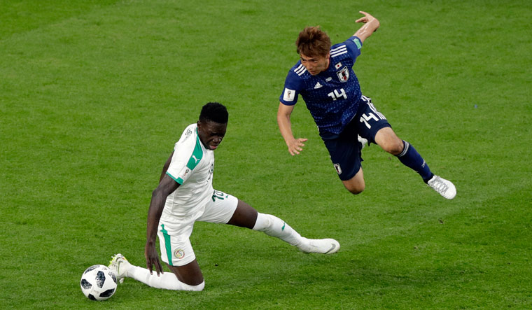 Senegal's Ismaila Sarr, left, and Japan's Takashi Inui battle for the ball | AP