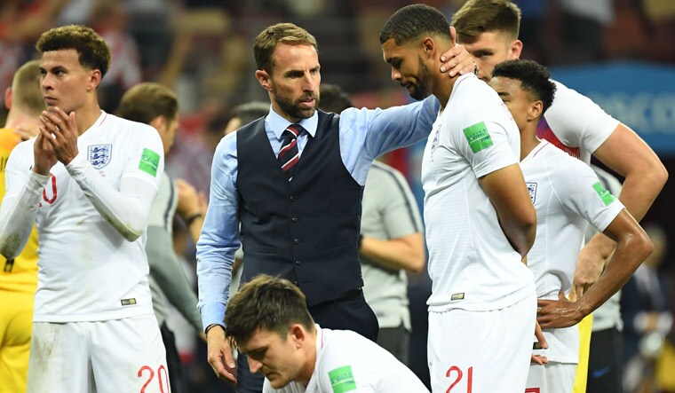 England coach Gareth Southgate comforts his players after their semifinal loss against Croatia | AFP
