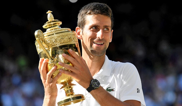 Serbia's Novak Djokovic celebrates with the trophy after winning the men's singles final against South Africa's Kevin Anderson | Reuters