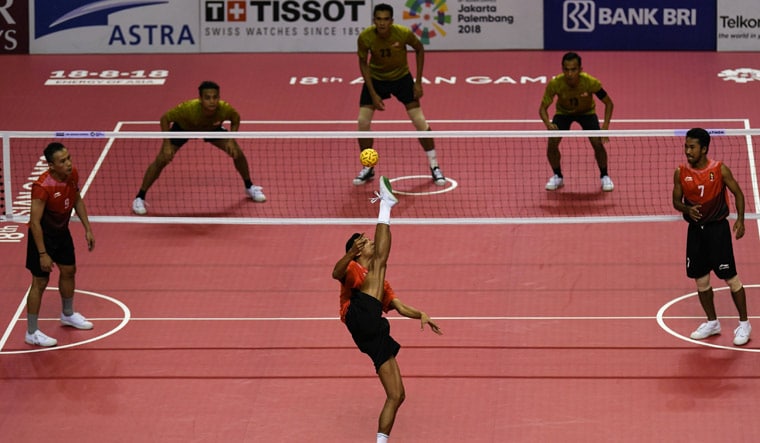 Indonesia's Abdul Halim Radjiu (bottom) serves during the sepak takraw men's team regu semifinal against Malaysia during the 2018 Asian Games in Palembang | AFP