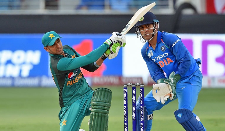 Pakistan batsman Shoaib Malik plays a shot as Indian wicketkeeper M.S. Dhoni looks on during the ODI Asia Cup cricket match at the Dubai International Cricket Stadium in Dubai on Sunday | AFP