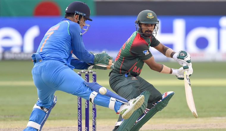 Liton Das plays a shot as wicketkeeper Mahendra Singh Dhoni looks on during the final of the Asia Cup at the Dubai International Cricket Stadium | AFP