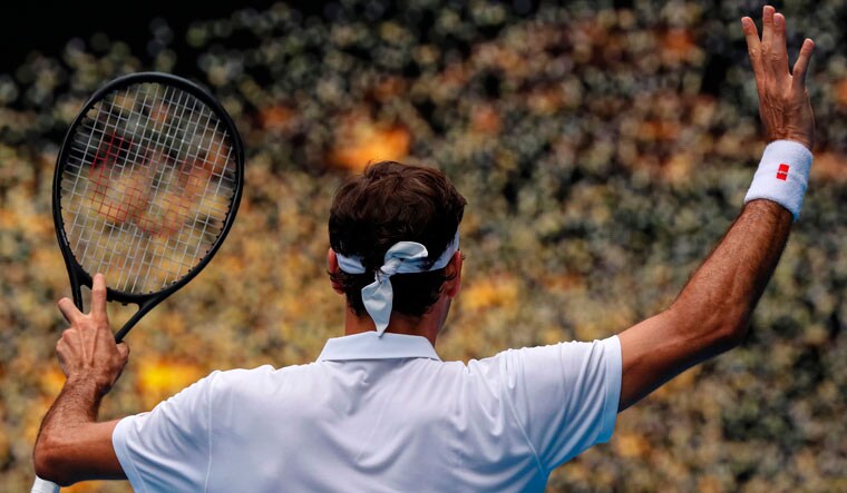 Roger Federer celebrates after beating Britain's Daniel Evans in their men's singles match on day three of the Australian Open in Melbourne | AFP