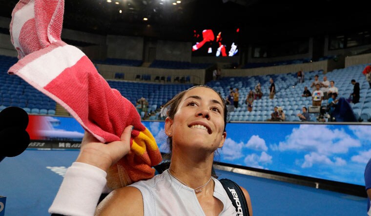 Garbine Muguruza throws her towel into the crowd as she celebrates after defeating Johanna Konta in their second round match at the Australian Open | AP