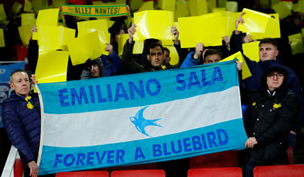 Fans hold up yellow sheets and a flag as a tribute to Emiliano Sala | Reuters
