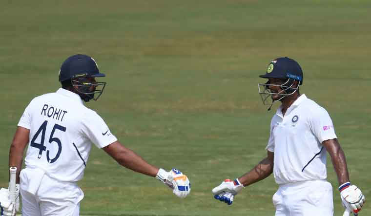 Indian cricketer Rohit Sharma (left) and Mayank Agarwal (right) gesture between the wickets during the first day's play of the first Test match between India and South Africa at the Dr. Y.S. Rajasekhara Reddy ACA-VDCA Cricket Stadium in Visakhapatnam | AFP