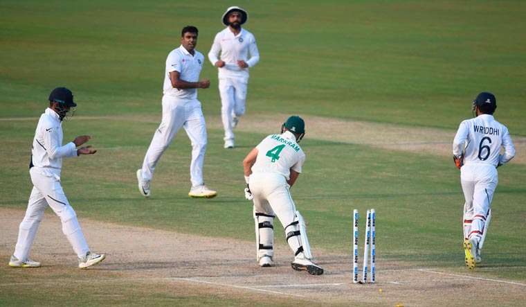 Aiden Markram (centre) is bowled out by Ravichandran Ashwin (second left) during the second day's play of the first Test match at the Dr Y.S. Rajasekhara Reddy ACA-VDCA Cricket Stadium in Visakhapatnam | AFP