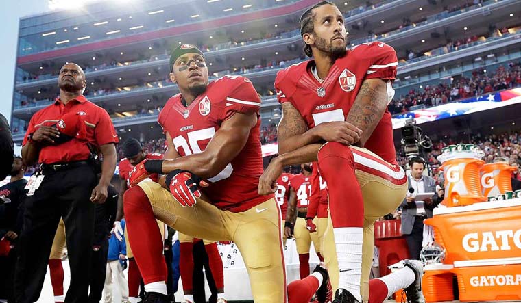 Kaepernick (right) and Eric Reid of the San Francisco 49ers kneel in protest during the national anthem prior to a game | AP