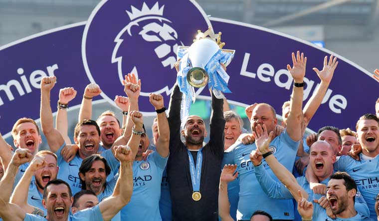 Manchester City manager Pep Guardiola lifts the Premier League trophy as they celebrate winning the title | Reuters