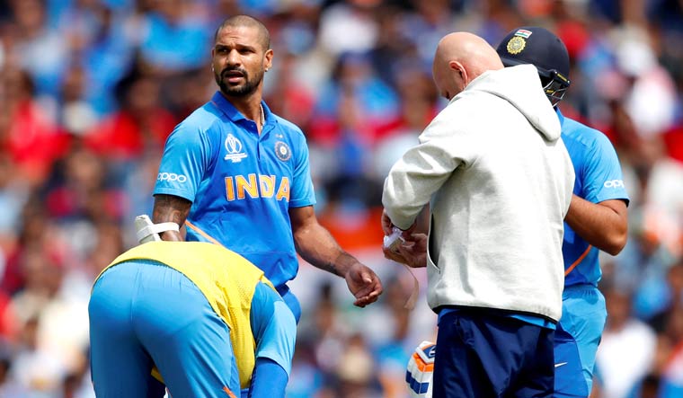 Shikhar Dhawan gets treatment on his left thumb after being hit by a Pat Cummins delivery, during the India-Australia match at The Oval | Reuters
