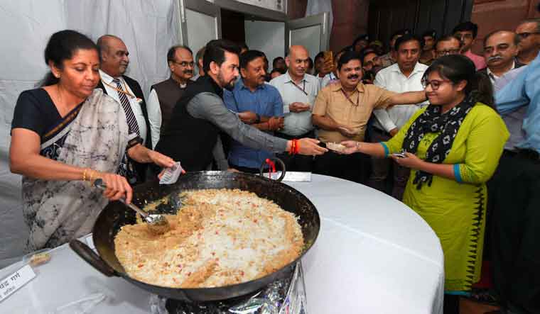 Union Minister for Finance Nirmala Sitharaman and MoS Anurag Thakur distribute halwa to officials during the 'halwa ceremony' to mark the beginning of printing of budgetary documents in New Delhi Saturday | PTI