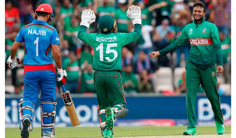 Bangladesh's Shakib Al Hasan (right) celebrates with teammate Mushfiqur Rahim (centre) after the dismissal of Afghanistan's Najibullah Zadran | AFP 