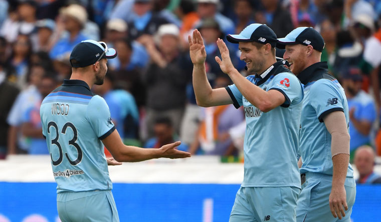 England's Chris Woakes (2R) celebrates with teammates after taking a catch to dismiss India's Rishabh Pant | AFP