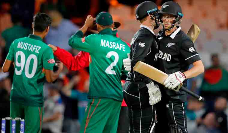 New Zealand's Mitchell Santner [right] and New Zealand's Lockie Ferguson [second right] celebrate after the 2019 Cricket World Cup group stage match between Bangladesh and New Zealand at The Oval in London | AFP