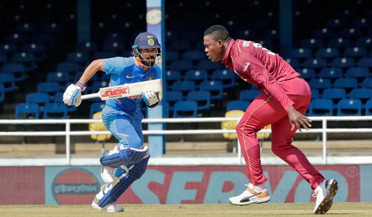 Virat Kohli run between the wickets as West Indies bowler Sheldon Cottrell looks on during their second One-Day International cricket match in Port of Spain, Trinidad | AP