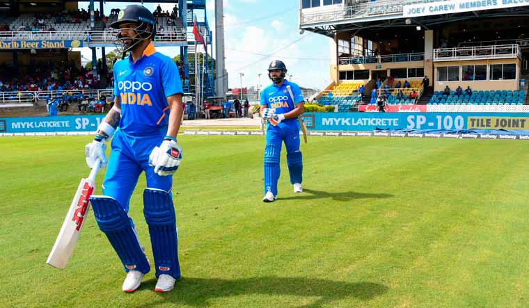 Shikhar Dhawan (left) and Rohit Sharma walk on to the field during the second ODI match between West Indies and India at Queens Park Oval in Port of Spain, Trinidad and Tobago | AFP