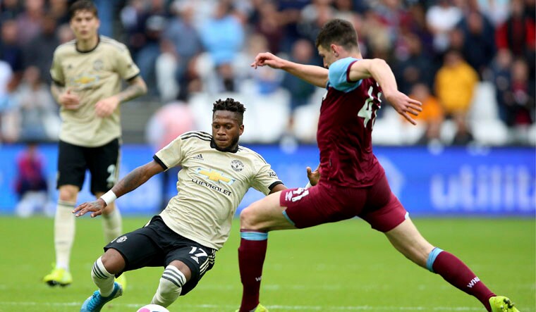 Manchester United's Fred, left, slides in on West Ham United's Declan Rice | AP