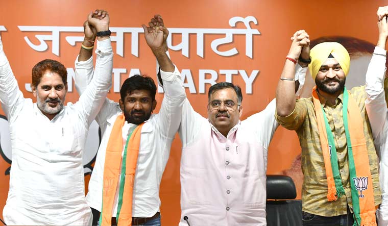 Yogeshwar Dutt (second left) and Sandeep Singh (fourth left) after joining the BJP, at the party headquarters in New Delhi | Sanjay Ahlawat