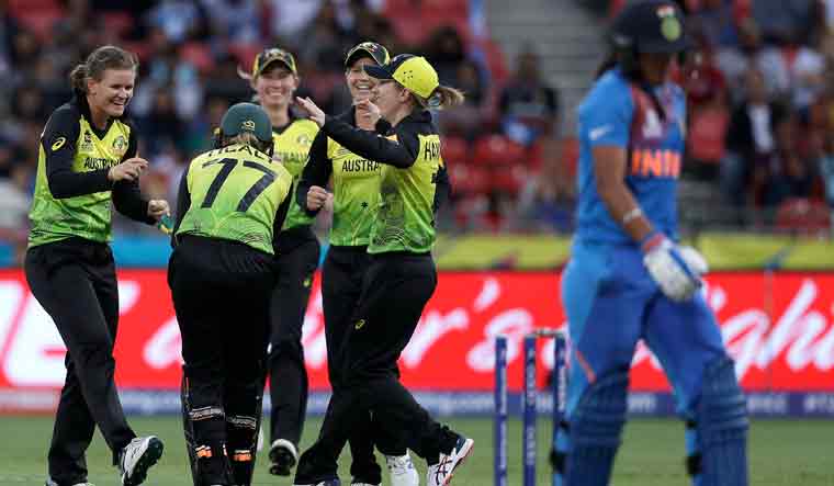 Indian skipper Harmanpreet Kaur walks off after she was stumped as the Australian teammates celebrate during the first game of the Women's T20 Cricket World Cup in Sydney | AP
