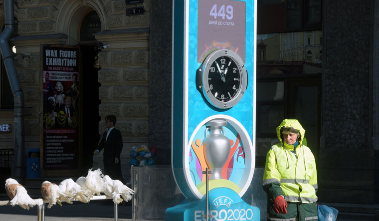 A municipal worker walks past the Euro 2020 countdown clock - displaying 449 days left before the event - in downtown Saint Petersburg on March 19 | AFP