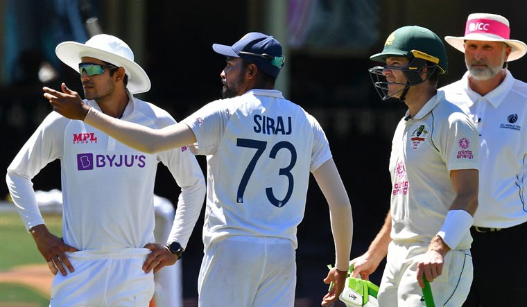 India's Mohammed Siraj (C) gestures next to Australia's captain Tim Paine (2R) as the game was halted after allegedly some remarks were made by the spectators on the fourth day of the third Test match at the Sydney Cricket Ground | AFP