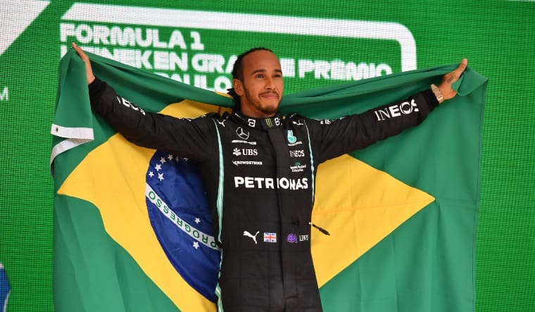 Lewis Hamilton holds the Brazil flag on the podium after winning the Formula One race in Sao Paolo | Twitter: @F1