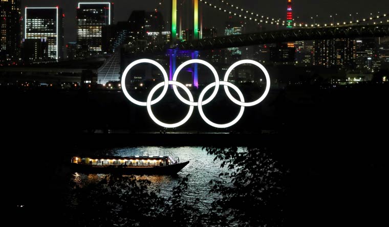 The Rainbow Bridge and Tokyo Tower are illuminated with Olympic colours to mark 100 days' countdown to the Olympics | Reuters
