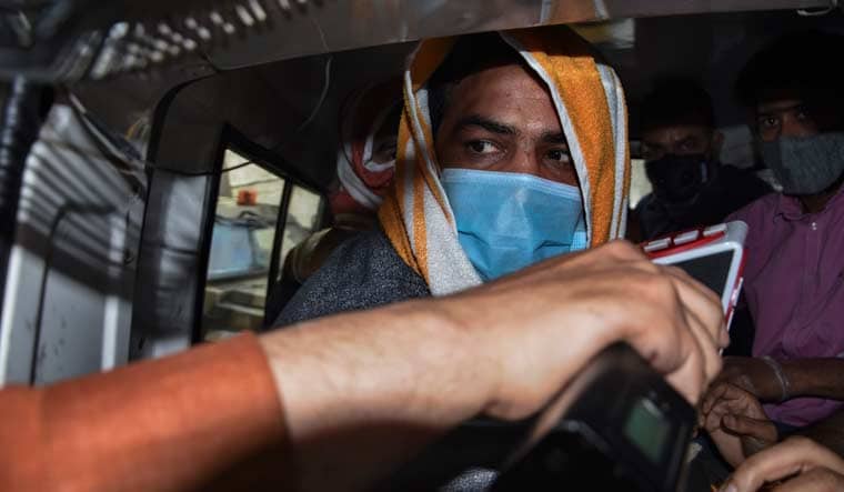 A television journalist tries to get a reaction from Indian wrestler and two-time Olympic medalist Sushil Kumar as he is taken away for medical procedures after being arrested by police in New Delhi, India, Sunday, May 23, 2021 | AP
