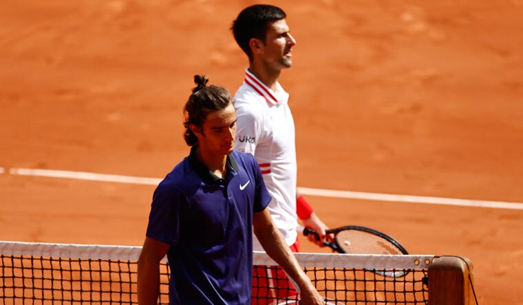Italy's Lorenzo Musetti with Serbia's Novak Djokovic after retiring injured from their fourth round match at the French Open | Reuters