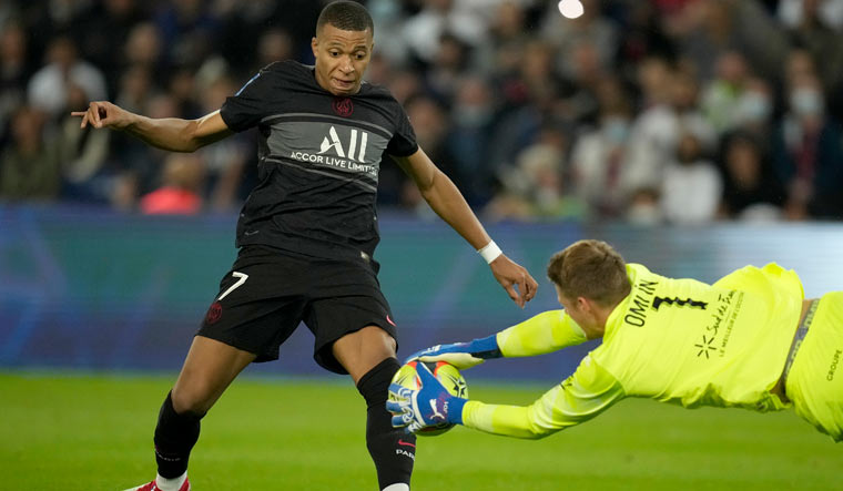 Montpellier's goalkeeper Jonas Omlin dives for a save in front of PSG's Kylian Mbappe | AP
