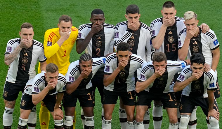 Germany players cover their mouths as they pose for a group photo before the World Cup group E match against Japan | AP
