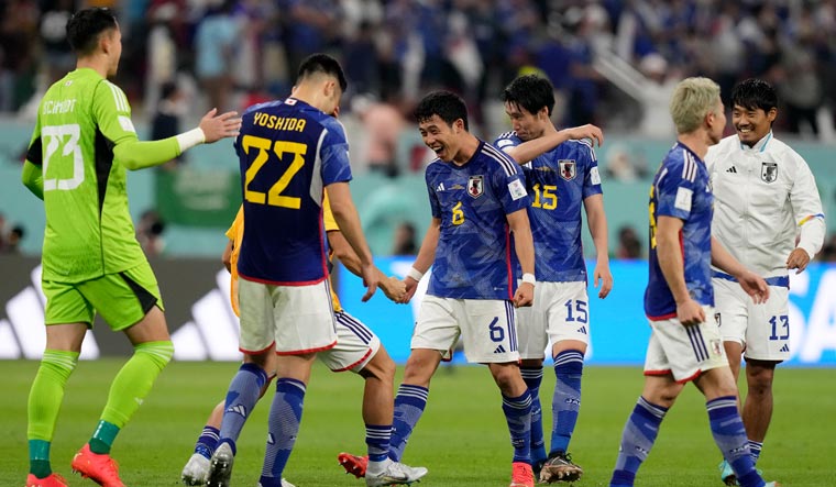 Japan's players celebrate after winning the World Cup group E match against Germany | AP