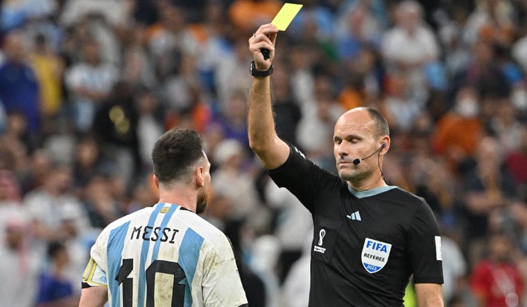 Spanish referee Antonio Mateu Lahoz shows a yellow card to Lionel Messi during the Qatar 2022 World Cup quarterfinal match between Netherlands and Argentina at Lusail Stadium | AFP