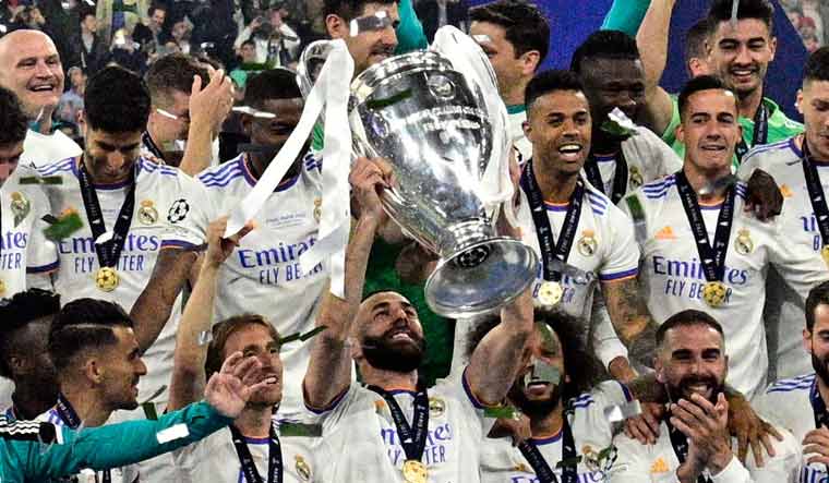 (File) Real Madrid's French forward Karim Benzema (C) and his teammates celebrate with the trophy after the UEFA Champions League final against Liverpool | AFP