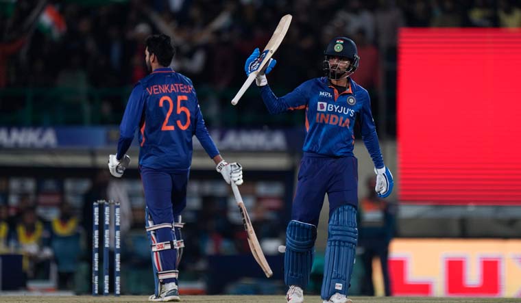 Shreyas Iyer, right, raises his bat to celebrate scoring fifty | AP