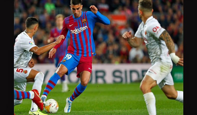 Barcelona's Ferran Torres, centre, challenges for the ball with Mallorca's Franco Russo, left, during a Spanish La Liga soccer match between FC Barcelona and Mallorca at the Camp Nou stadium in Barcelona, Spain, Sunday, May 1, 2022 | AP