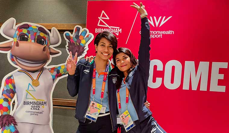 Boxers Lovlina Borgohain and Nikhat Zareen pose with 'Perry the Bull', the mascot of the Commonwealth Games 2022, in Birmingham | PTI