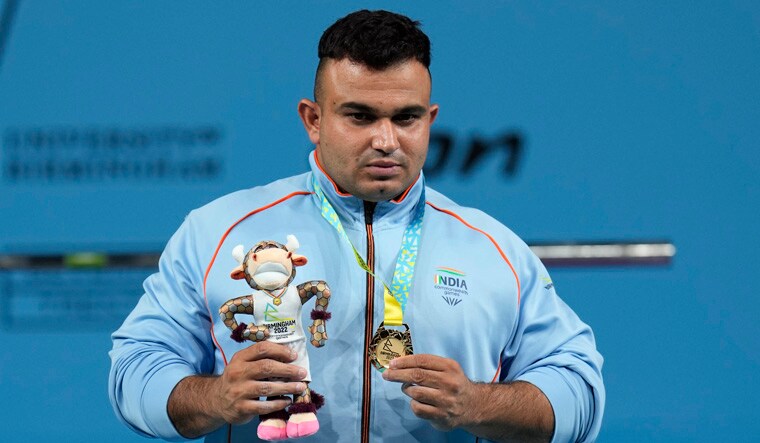 India's Sudhir poses with the gold medal he won at the men's heavyweight para powerlifting final at the Commonwealth Games at The NEC in Birmingham, England, Thursday, Aug. 4, 2022. (AP Photo/Aijaz Rahi)