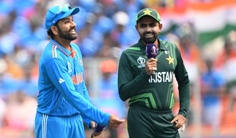 India captain Rohit Sharma (L) tosses the coin as Pakistan captain Babar Azam watches before the start of their 2023 ODI World Cup match in Ahmedabad | AFP