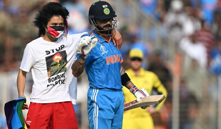 A pitch invader stands next to India's Virat Kohli during the World Cup final | AFP