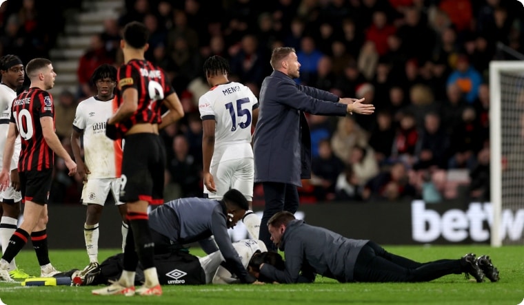 Luton Town manager Rob Edwards gestures on the pitch as his player Tom Lockyer receives treatment | AP