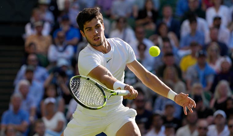 Spain's Carlos Alcaraz returns to Denmark's Holger Rune in a men's singles match on day ten of the Wimbledon tennis championships in London | AP