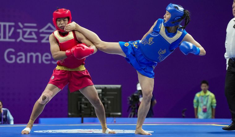 India's Naorem Roshibina Devi (in blue) fights against China's Xiaowei Wu in the finals of the Women's 60 kg Wushu event at the 19th Asian Games | PTI
