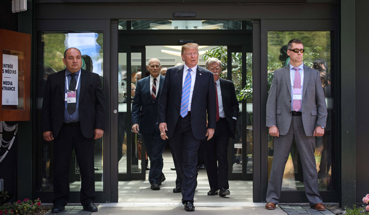 US President Donald Trump (C) leaves with Chief of Staff John Kelly (CL) and National Security Advisor John Bolton (CR) after holding a press conference ahead of his early departure from the G7 Summit | AFP