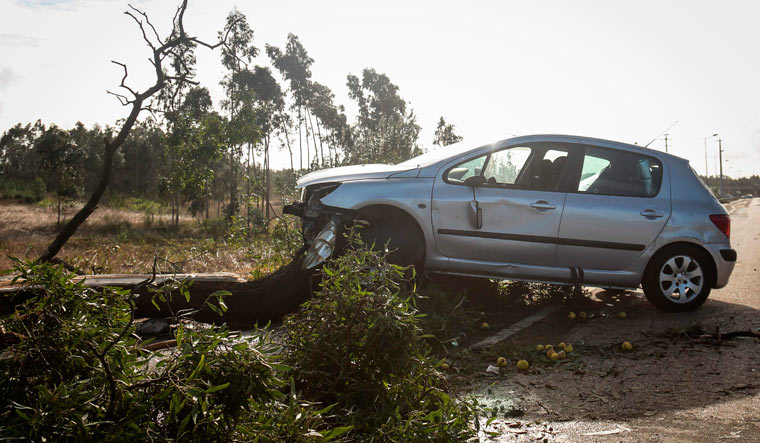 A damaged car is pictured in Figueira da Foz on Sunday after the post-tropical storm Leslie reached Portugal | AFP