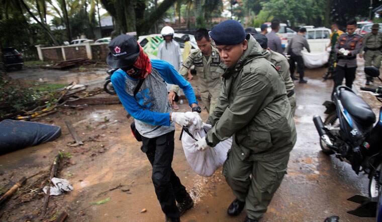 Rescue team members carry the dead body of a victim after a tsunami hit Tanjung Lesung beach in Banten, Indonesia | Reuters