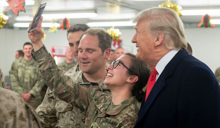 US President Donald Trump takes a picture with US military during an unannounced trip to Al Asad Air Base in Iraq | PTI