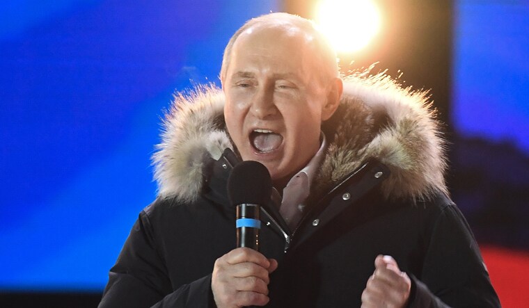 Presidential candidate, President Vladimir Putin addresses the crowd during a rally and a concert celebrating the fourth anniversary of Russia's annexation of Crimea at Manezhnaya Square in Moscow | AFP